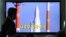 People watch a TV broadcasting a report about the cancellation of a launch of the Korea Space Launch Vehicle-1, at Seoul Railway Station in Seoul, South Korea, November 29, 2012.