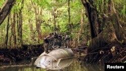 Oficiales de policía ecuatorianos se paran sobre un submarino diseñado para transportar drogas hacia los Estados Unidos, en San Lorenzo, al norte de la provincia de Esmeraldas, el 2 de julio de 2010.