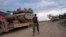 FILE - An Israeli soldier works on loading a tank onto a transport truck at an area near the Israeli-Lebanese border, as seen from northern Israel, Dec. 4, 2024. 