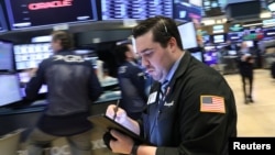 Traders work on the floor at the New York Stock Exchange (NYSE) in New York, April 23, 2019. 