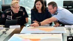 Queensland Fire and Emergency Services Commissioner, Katarina Carroll, from left, Queensland Premier Annastacia Palaszczuk and Queensland Police Deputy Commissioner Bob Gee discuss the approaching cyclone at the Emergency Services Complex in Brisbane, March 19, 2019.