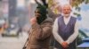 An Indian police officer stands guard near a cutout portrait of Indian Prime Minister Narendra Modi displayed at the main market in Srinagar, Indian-controlled Kashmir, Dec. 11, 2023.