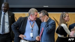 El director general de la OMS, Tedros Adhanom Ghebreyesus, escucha al jefe de emergencias de la OMS, Mike Ryan, durante una reunión de las Naciones Unidas sobre la enfermedad del Ébola, 15 de julio 2019.