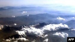 FILE - An aerial view taken from a plane shows clouds moving through the snow-covered peaks of the Alborz mountains in northern Iran, Oct. 18, 2014.