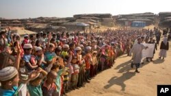 FILE - Rohingya children and refugees raise their hands and shout that they won't go back to Myanmar during a demonstration at Kutupalong near Cox's Bazar, Bangladesh, Jan. 22, 2018. 