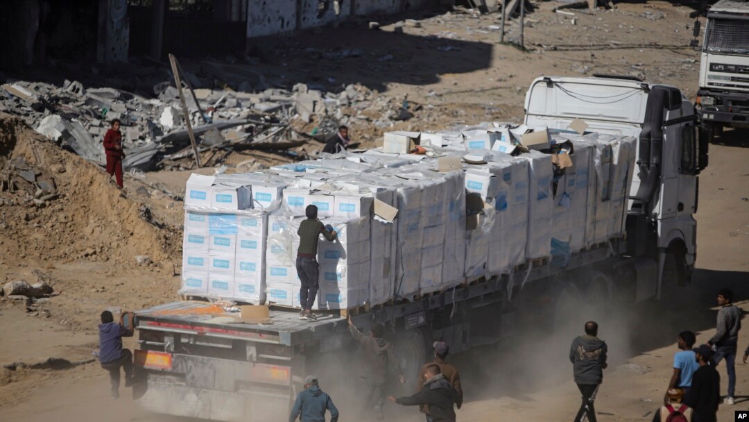 Palestinci jure za kamionima humanitarne pomoći koji su stigli preko prelaza Kerem Shalom iz Egipta u pojas Gaze, u Rafah, 21. januara 2025.