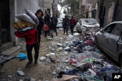 FILE - Palestinians look at the destruction after an Israeli airstrike in Rafah, Gaza Strip, February 9, 2024.