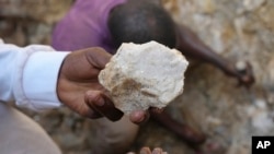 Un homme montre une pierre de lithium provenant d'un site minier illégal à Paseli, dans le centre-nord du Nigeria, le mardi 5 novembre 2024. (AP Photo/Sunday Alamba)