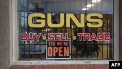 FILE - An "Open" sign is seen on a gun store in Benson, Arizona, Sept. 29, 2016.
