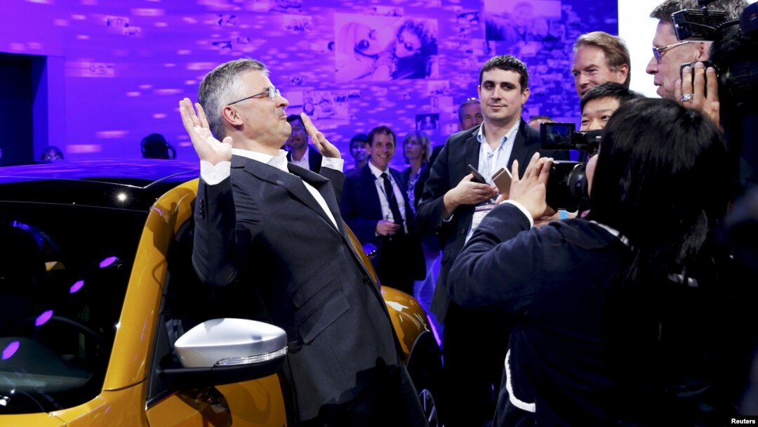 FILE - Michael Horn, President and CEO of Volkswagen America, reacts to being mobbed by the media after he apologized for the Volkswagen diesel scandal at the LA Auto Show in Los Angeles, California, Nov. 18, 2015.