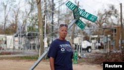 Sissy Karr, 55, poses for a portrait amid damage from Hurricane Michael in Panama City, Florida, Nov. 5, 2018. 