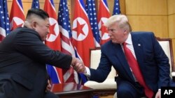 Pemimpin Korut Kim Jong Un (kiri) dan Presiden AS Donald Trump dalam pertemuan di Zona Demiliterisasi Korea 30 Juni 2019 lalu (foto: dok). 