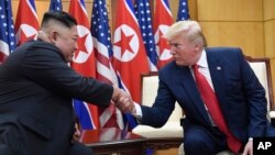 Pemimpin Korea Utara Kim Jong Un (kiri) dan Presiden AS Donald Trump dalam pertemuan terakhir mereka di Zona Demiliterisasi Korea 30 Juni 2019 lalu (foto: dok).