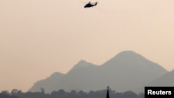 An MI-35M military helicopter flies over Christian church in Lashio, February 19, 2015.