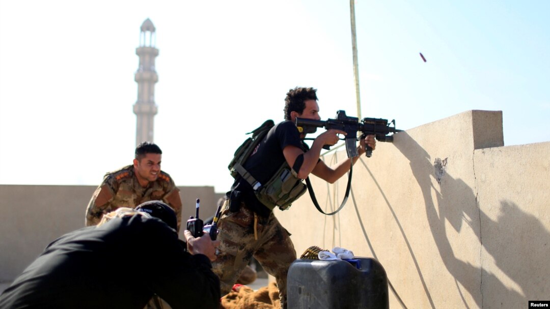 A member of the Iraqi Counter Terrorism Service fires his weapon at Islamic State militants in the al-Zahraa neighborhood of Mosul, Iraq, Nov. 13, 2016. The Iraqi military announced Sunday that its forces captured the ancient city of Nimrud.