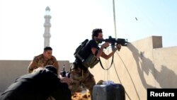 A member of the Iraqi Counter Terrorism Service fires his weapon at Islamic State militants in the al-Zahraa neighborhood of Mosul, Iraq, Nov. 13, 2016. The Iraqi military announced Sunday that its forces captured the ancient city of Nimrud.