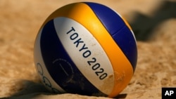 A volleyball rests in the sand during during women's beach volleyball practice at the 2020 Summer Olympics, Monday, July 19, 2021, in Tokyo. (AP Photo/Charlie Riedel)