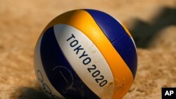 A volleyball rests in the sand during during women's beach volleyball practice at the 2020 Summer Olympics, July 19, 2021, in Tokyo.