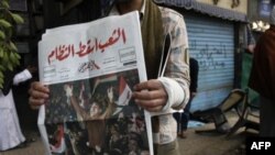Египтянин читает газету на первой полосе которой - статья об отставке Мубарака.
