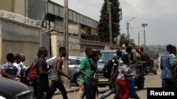 Des passants courent alors qu'ils quittent le port d'Abidjan après avoir entendu des tirs, en Côte d'Ivoire, le 18 janvier 2017. 