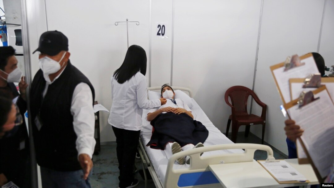 Una trabajadora de la salud descansa en una cama mientras se recupera después de recibir una primera dosis de la vacuna Moderna contra la enfermedad por coronavirus (COVID-19), en el hospital temporal Parque de la Industria en la Ciudad de Guatemala, Guatemala.