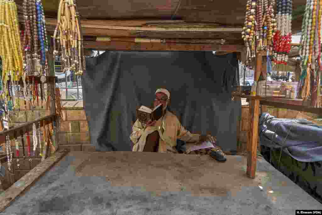 Hajj Ibrahim, a prayer&#39; beads seller, is reading the Quran while waiting for customers in Al Sayeda Zainab (in old Cairo).