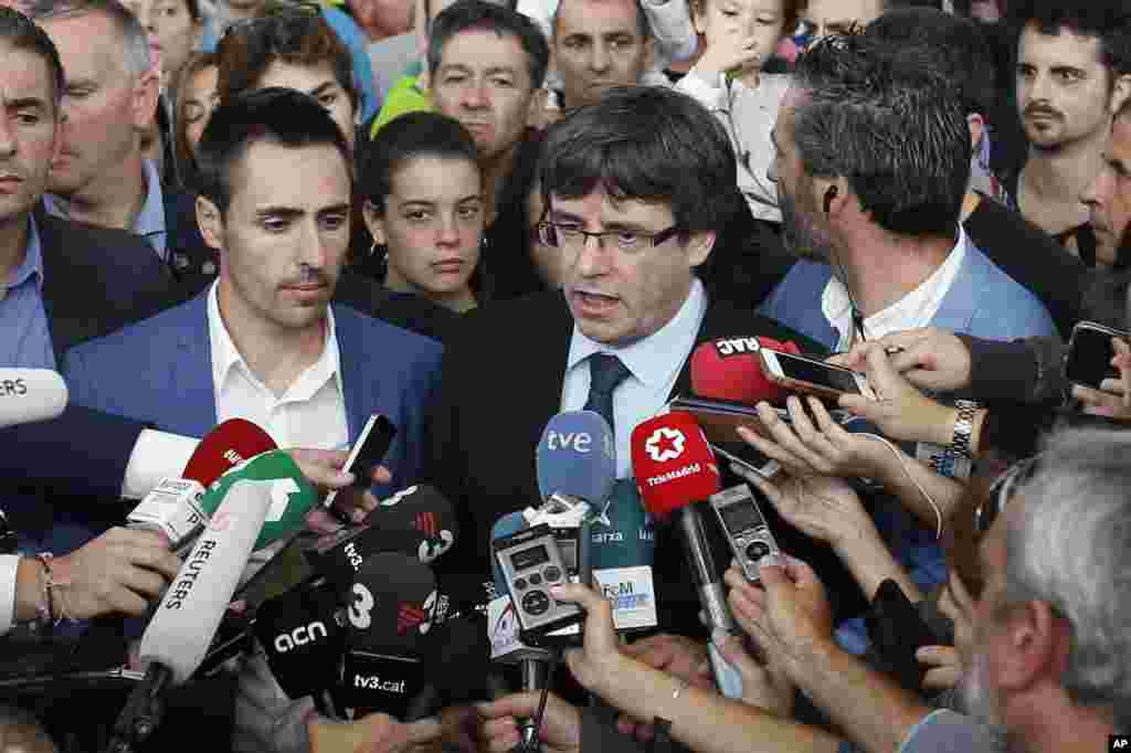 El presidente de Cataluña, Carles Puigdemont, habla a los medios de comunicación en un centro deportivo, asignado como mesa de votación por el gobierno catalán en Sant Julià de Ramis, cerca de Girona, el 1 de octubre de 2017.