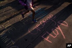 George Floyd's name is written on a sidewalk near the intersection of Florence and Normandie Avenues in Los Angeles, April 20, 2021, after a guilty verdict was announced at the trial of former Minneapolis police Officer Derek Chauvin.