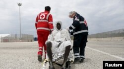 Des éléments de la Croix rouge assistent un migrant qui a débarqué au port scilien d'Augusta, Italy, 31 mai 2013