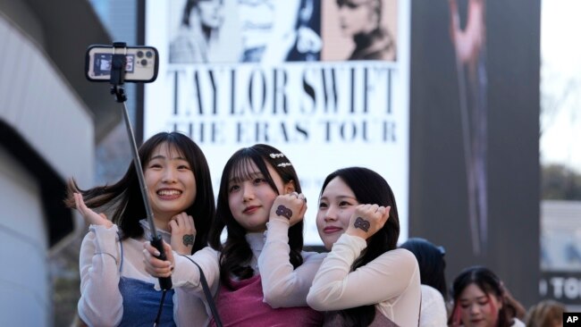 Women pose for a selfie before Taylor Swift's concert at Tokyo Dome in Tokyo, on Feb. 10, 2024.