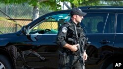 A Capitol Hill Police officer walks past an automobile with the driver's window damaged at the scene of a shooting in Alexandria, Virginia, June 14, 2017.