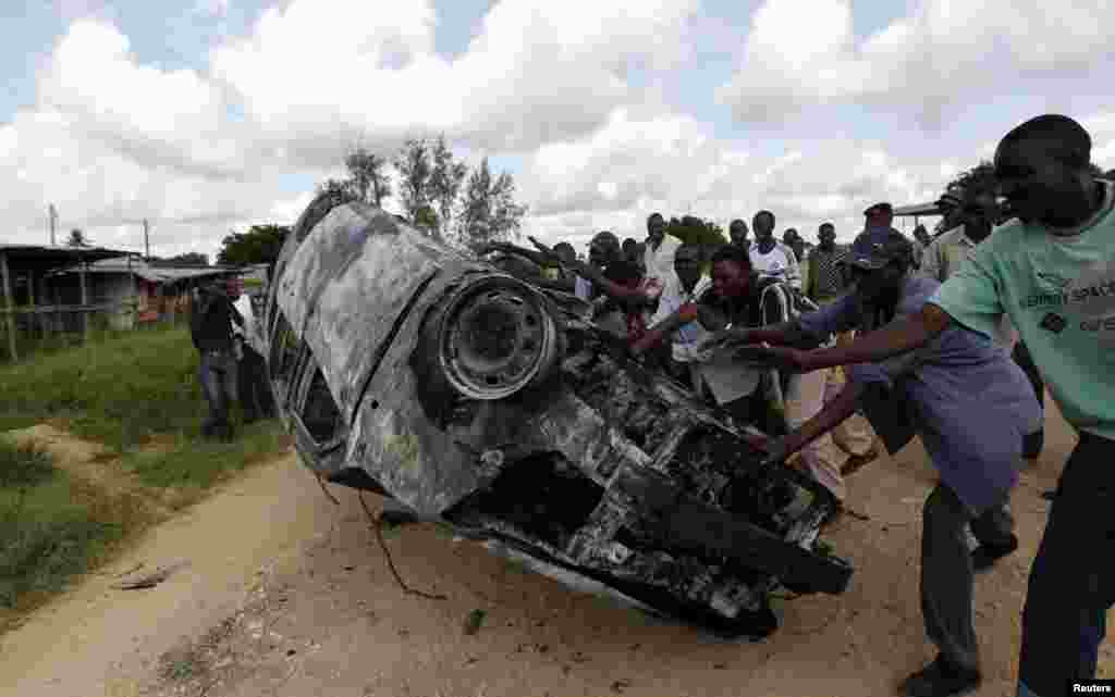 Residents remove a road barricade as they protest along the streets after gunmen attacked the coastal Kenyan town of Mpeketoni, June 17, 2014.