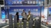 FILE - A salesman explains building types to customers at a real estate show in Shenzhen, Guangdong province, China, Oct. 12, 2024.