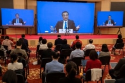 Chinese Premier Li Keqiang speaks on screen during a press conference by video conferencing at the end of the National People's Congress in Beijing on Thursday, May 28, 2020. China’s ceremonial legislature on Thursday endorsed a national security…