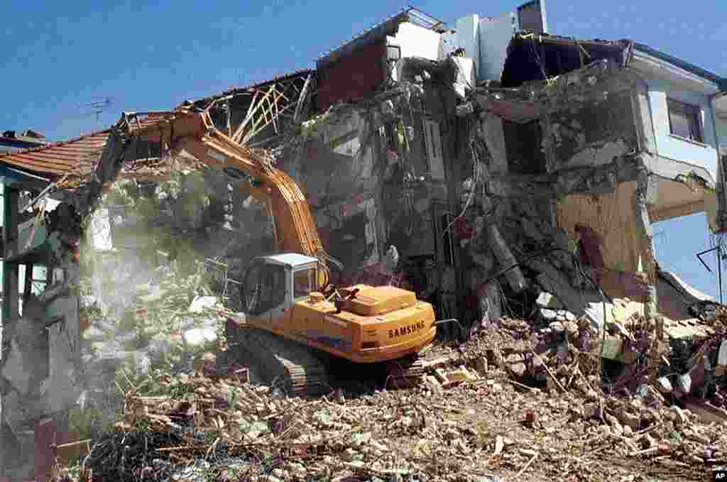 A bulldozer tears down a damaged building as part of clean up following the earthquake in the Turkish western city of Yalova, September 7, 1999. (AP)