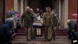 Servicemen carry the coffin of Ukrainian Captain Serhii Vatsko in Boiarka, Ukraine, on March 29, 2024. Vatsko, who was killed on the front line of eastern Ukraine on March 24, joined the military in 2014.