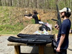 Landon Burke and Matt Reierstad aim their semiautomatic guns for target practice in Hampton, Tennessee. Some of their guns are not permitted on indoor gun ranges so they drove out-of-state to find an outdoor range. (Carolyn Presutti/VOA)