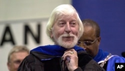 FILE - Caroll Spinney, best known for his TV character "Big Bird" from Sesame Street, receives an honorary doctorate from Eastern Connecticut State University President David G. Carter, rear, in Willimantic, Connecticut, May 21, 2000. 