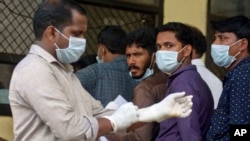 Indians standing in a queue outside a hospital wear masks as a precautionary measure against the Nipah virus at the Government Medical College hospital in Kozhikode, in the southern Indian state of Kerala, May 21, 2018.