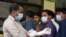 Người Ấn Độ mang khẩu trang ngừa virus Nipah đứng bên ngoài bệnh viện Trường Y của Chính phủ tại Kozhikode, bang Kerala, ngày 21/5/2018.