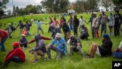 Homeless recyclers and other destitute people, some of whom said they have not eaten in three days practice limited social distancing as they lineup in a Johannesburg park, waiting to receive food baskets from private donors, Thursday, April 9, 2020.