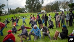 Homeless recyclers and other destitute people, some of whom said they have not eaten in three days, practice limited social distancing as they lineup in a Johannesburg park, waiting to receive food baskets from private donors, April 9, 2020.