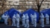 在有新冠病毒阳性民众居家隔离的北京某居民楼外，穿着白色防护服的防疫人员集合，开始他们的执勤班次。(2022年12月8日)
