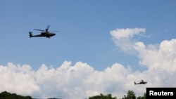 FILE - AH-64 Apache helicopters fly during a live-fire drill of the U.S. Army's 1st Armored Brigade Combat Team, 1st Armored Division at the Rodriguez Live Fire Complex, in Pocheon, South Korea, Aug. 14, 2024.