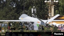 FILE - Military vehicles carrying Wing Loong, a Chinese-made medium-altitude long-endurance unmanned aerial vehicle, take part in a military parade in Beijing, Sept. 3, 2015.