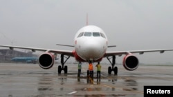 FILE - Ground staff check VietJet A320 airplane before departure for Bangkok, Noi Bai international airport, Hanoi, September 2013.