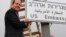 In this photo released by the Jerusalem Municipality, Jerusalem mayor Nir Barkat poses with a new road sign to the new U.S. Embassy in Jerusalem, Israel, May 7, 2018.