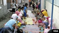 Anak-anak dan perempuan di tempat hunian sementara Dongkelsari berbuka puasa dengan menu sederhana teh manis dan nasi bungkus, Senin (29/8).