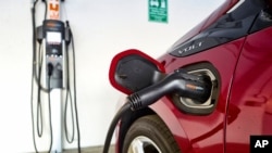 FILE - A Chevrolet Volt hybrid car is hooked up at a ChargePoint charging station at a parking garage in Los Angeles, Oct. 17, 2018. 