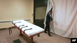 Larry Greene, directeur de l'information publique du Southern Ohio Correctional Facility, montre comment un rideau est tiré entre la chambre de la mort et la salle des témoins de la prison de Lucasville, Ohio., en novembre 2005. (Photo AP/Kiichiro Sato)